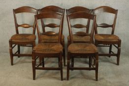 A set of six stained oak Arts & Crafts style bar dining chairs, with straw seats, raised on shaped