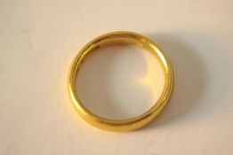 A 22ct yellow gold court shaped wedding band. Hallmarked: WWLd, Sheffield, 1907. Ring size L. Weight