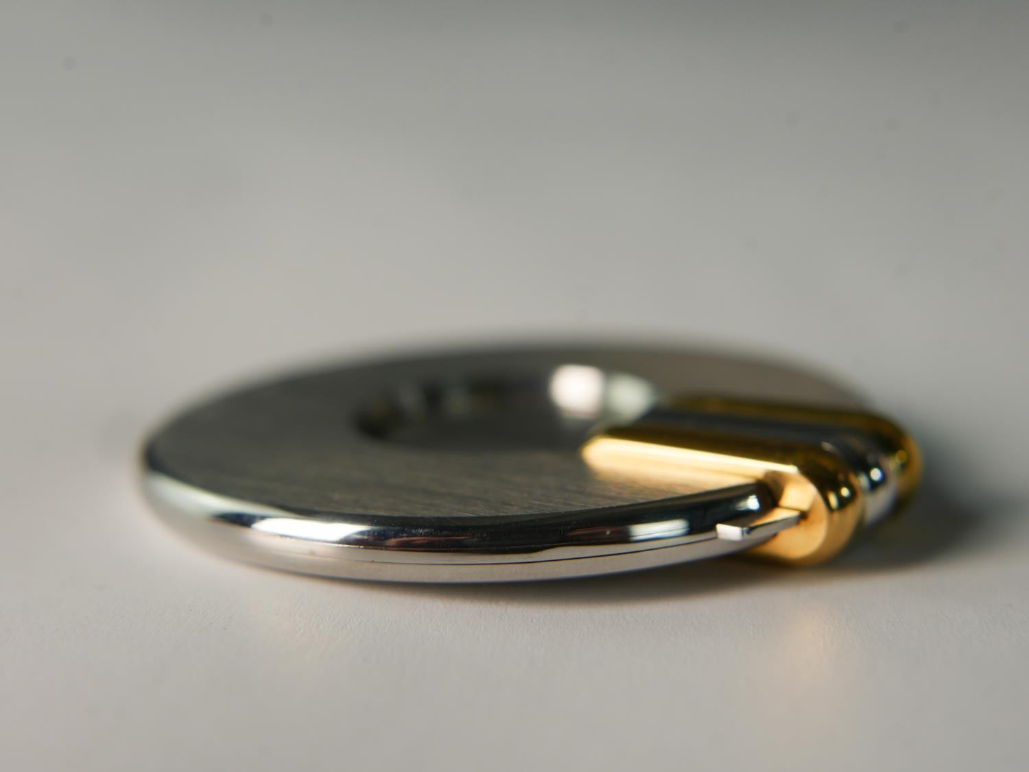 A late 20th century circular brushed steel Cartier cigar cutter, with bi-colour handle, impressed - Image 3 of 7