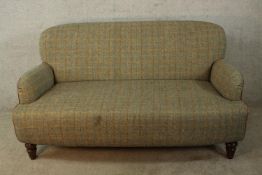 A 19th century Howard style two seater sofa, upholstered in Harris tweed style fabric, raised on