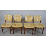 A set of four mid 20th century teak framed and vinyl Meredew button back chairs raised on