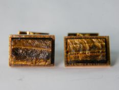 A pair of 18 carat yellow gold and tiger-eye hinged cufflinks. The smaller side with engraved bark