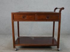 A mid 20th century Chinese hardwood, (possibly cherrywood), two drawer trolley with shelf below,