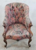 A 19th century mahogany framed upholstered spoon back armchair raised on carved cabriole supports