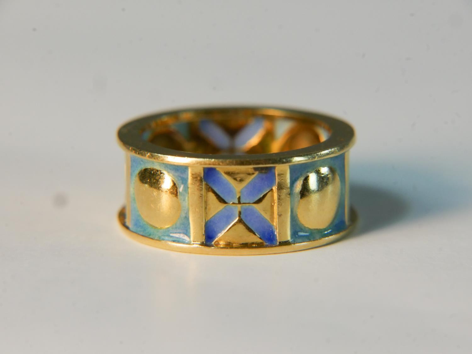 A contemporary 18 carat yellow gold and enamel sectioned XO design band. Stamped 750 and signed