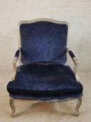 An early 20th century silver painted French style open armchair, with blue upholstered stuff over