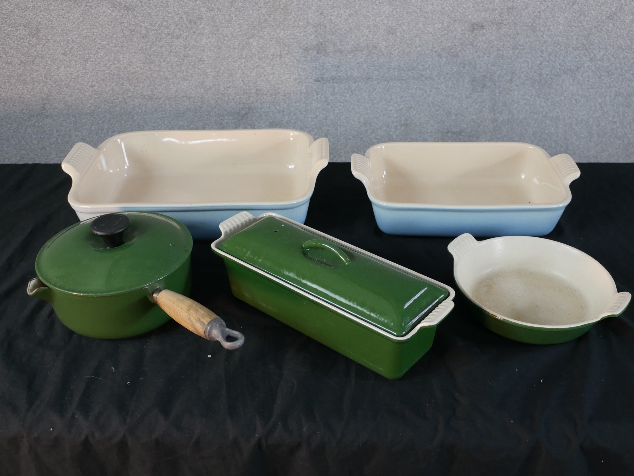 Five pieces of Le Creuset cooking items comprising three oven dishes, fish kettle and a lidded