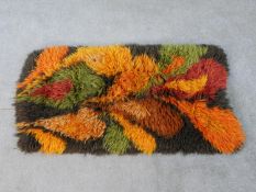 A contemporary woollen floral pattern rug.L.116 W.67cm