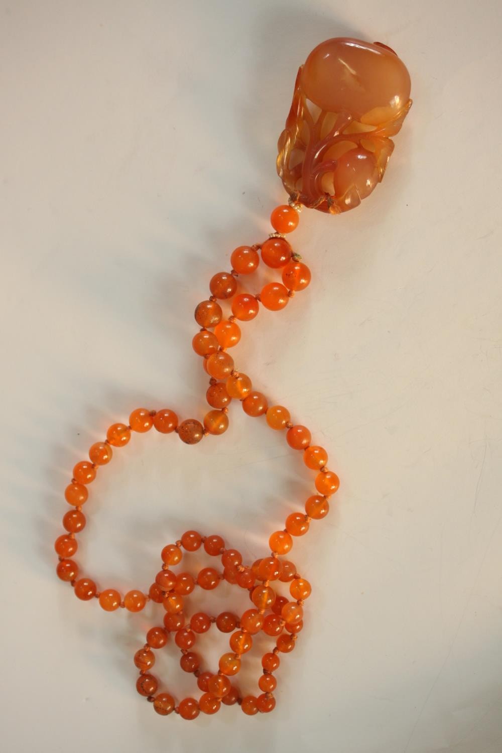 An early 20th century Chinese carved carnelian necklace, the carved pendant in the form of two - Image 7 of 8