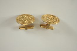 A pair of 9 carat yellow gold oval cufflinks, with scrollwork decoration, within beadwork border.