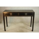 A 20th century Chinese style painted two drawer hardwood table, raised on tapering supports