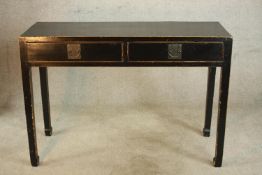 A 20th century Chinese style painted two drawer hardwood table, raised on tapering supports