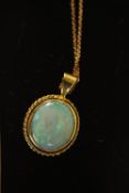 A boxed opal and 9ct yellow gold pendant and chain. The pedant sent with an oval opal cabochon