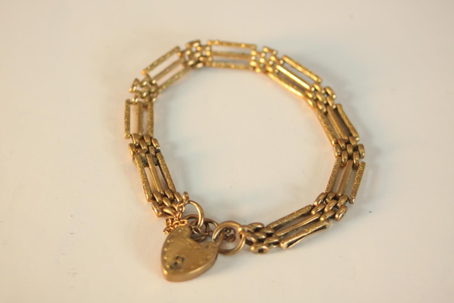 A 9ct rose gold Victorian engraved gate link bracelet charm bracelet with heart padlock. Hallmarked: