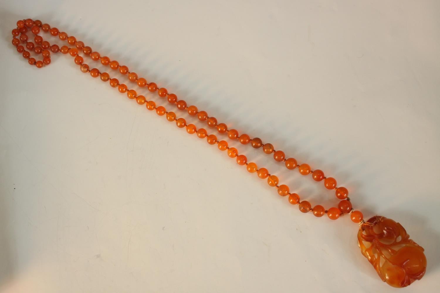 An early 20th century Chinese carved carnelian necklace, the carved pendant in the form of two - Image 8 of 8