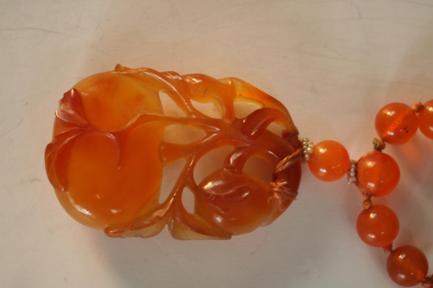 An early 20th century Chinese carved carnelian necklace, the carved pendant in the form of two - Image 3 of 8