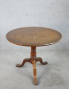 A 19th century mahogany tilt top tripod table, with turned baluster central raised on three outswept