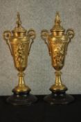 A pair of late 19th century French gilt metal twin handled urn form candlesticks on ebonised