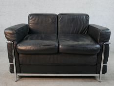 A contemporary Le Corbusier style black leather and chrome plated two seater settee, raised on tubul