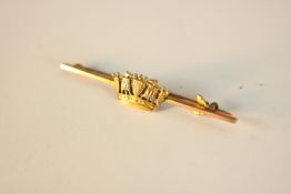 A 9ct yellow gold bar brooch with gold crown with ship sail detailing. Secure hinged pin with safety