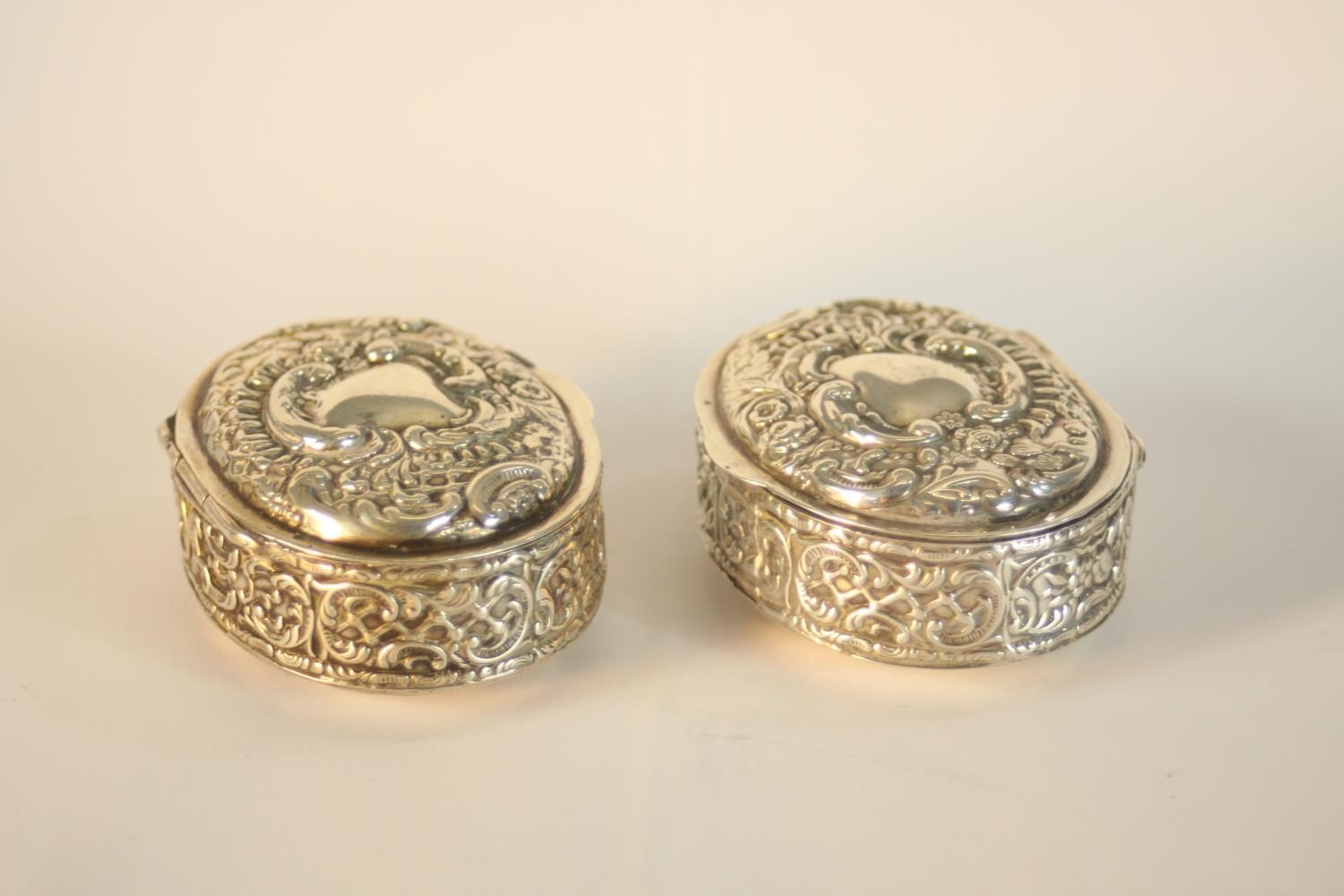 A pair of Edward VII hallmarked silver oval trinket boxes, Birmingham 1902, each with repousse