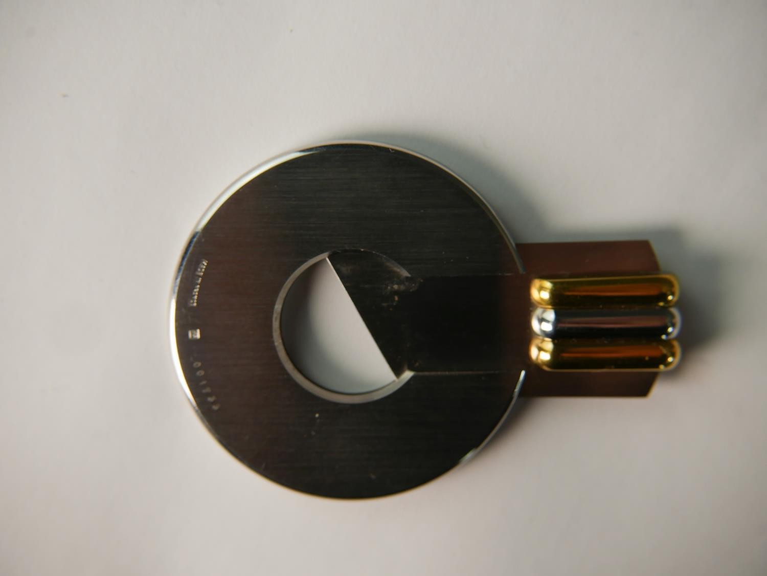 A late 20th century circular brushed steel Cartier cigar cutter, with bi-colour handle, impressed - Image 5 of 7