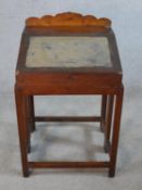 A late 19th/early 20th century elm teachers desk, the sloped top opening to reveal fitted
