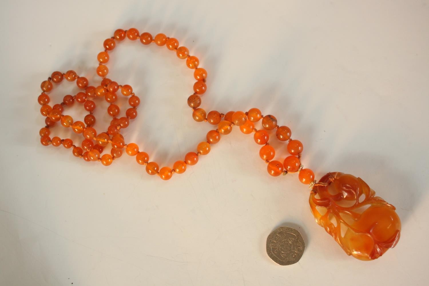 An early 20th century Chinese carved carnelian necklace, the carved pendant in the form of two - Image 2 of 8