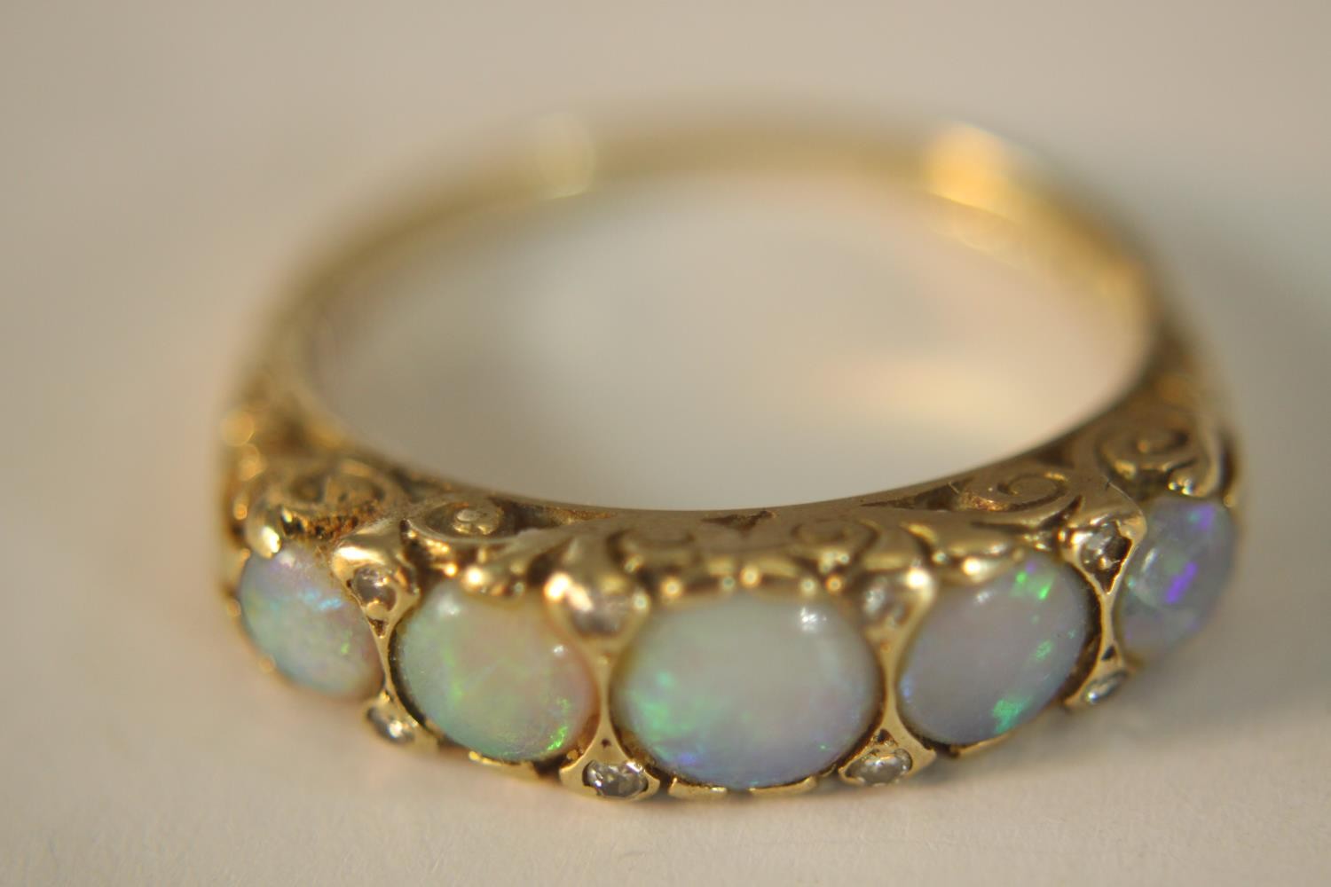 A 9ct carat yellow gold carved half hoop five stone Opal and diamond ring. Set with five round