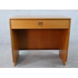 A 1970s G-Plan teak dressing table, with single long drawer, raised on shaped supports. H.72 W.77