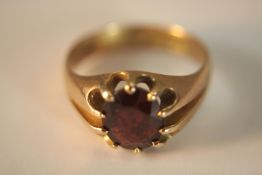 A Victorian 9ct gold Garnet signet style ring. Set with an oval mixed cut almandine garnet with an