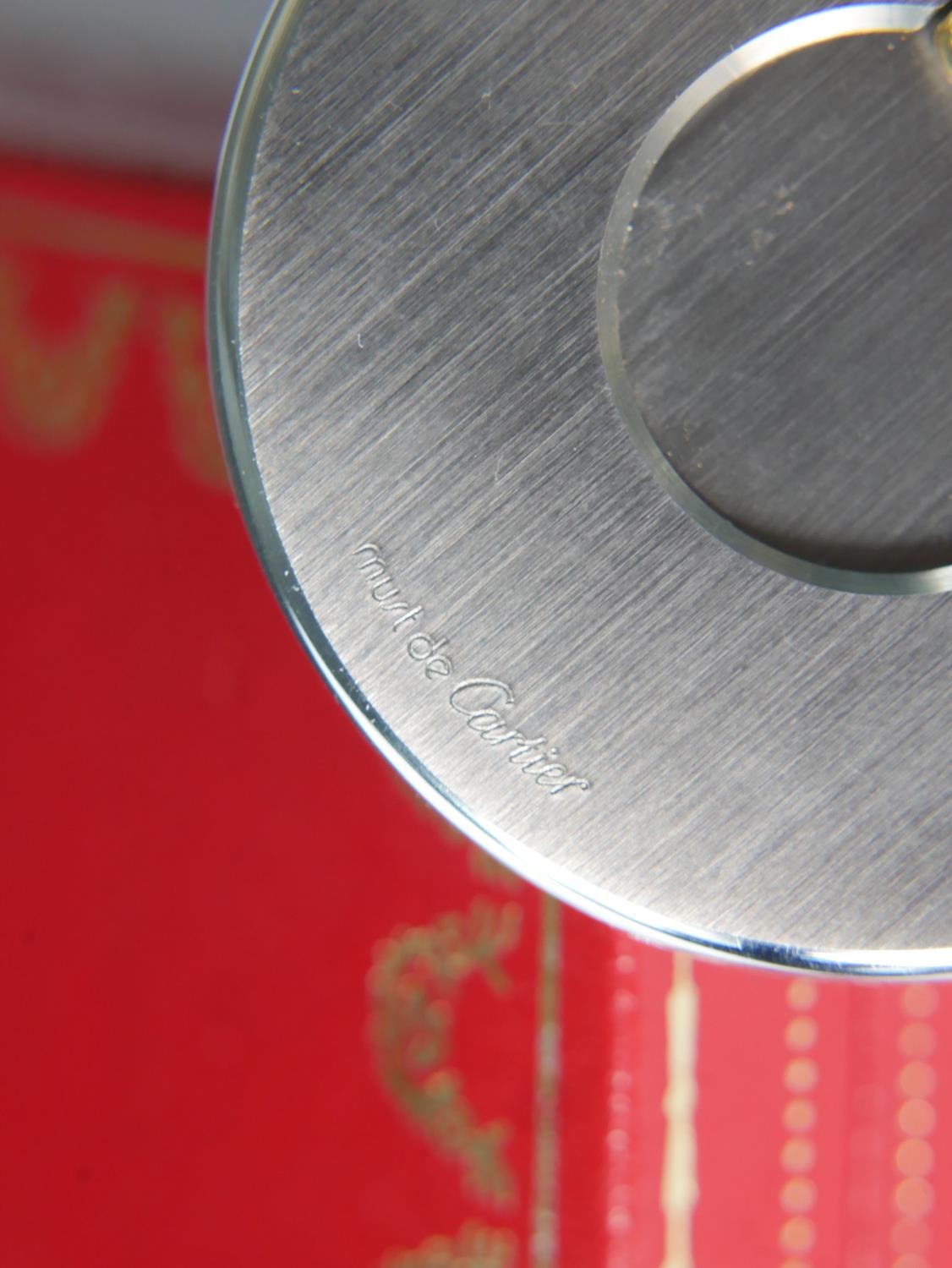 A late 20th century circular brushed steel Cartier cigar cutter, with bi-colour handle, impressed - Image 7 of 7