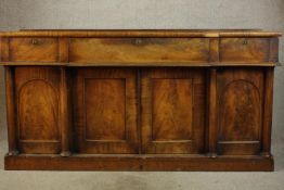 A 19th century mahogany sideboard with three drawers and four cupboard doors raised on block