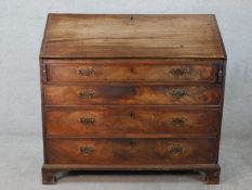 A George III mahogany fall front fitted bureau, with four graduating drawers raised on shaped