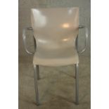 A mid 20th century hard plastic and brushed steel open armchair, raised on straight supports.