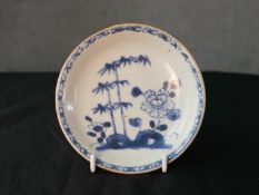 A mid 18th century Chinese café au lait blue and white porcelain saucer dish, decorated with flowers
