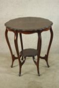 A late Victorian mahogany two tier occasional table, raised on six cabriole supports terminating in