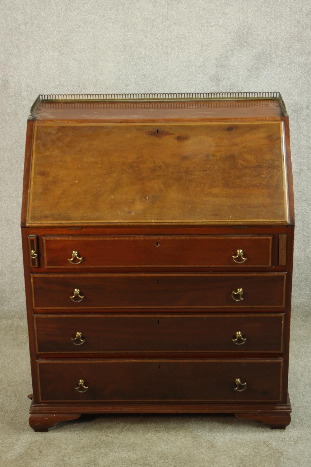 An Edwardian inlaid mahogany fall front writing bureau, with brass pierced gallery, the fall front