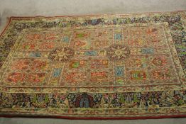 An 20th century Persian woollen sectional rug, with all over floral and geometric panels and border.