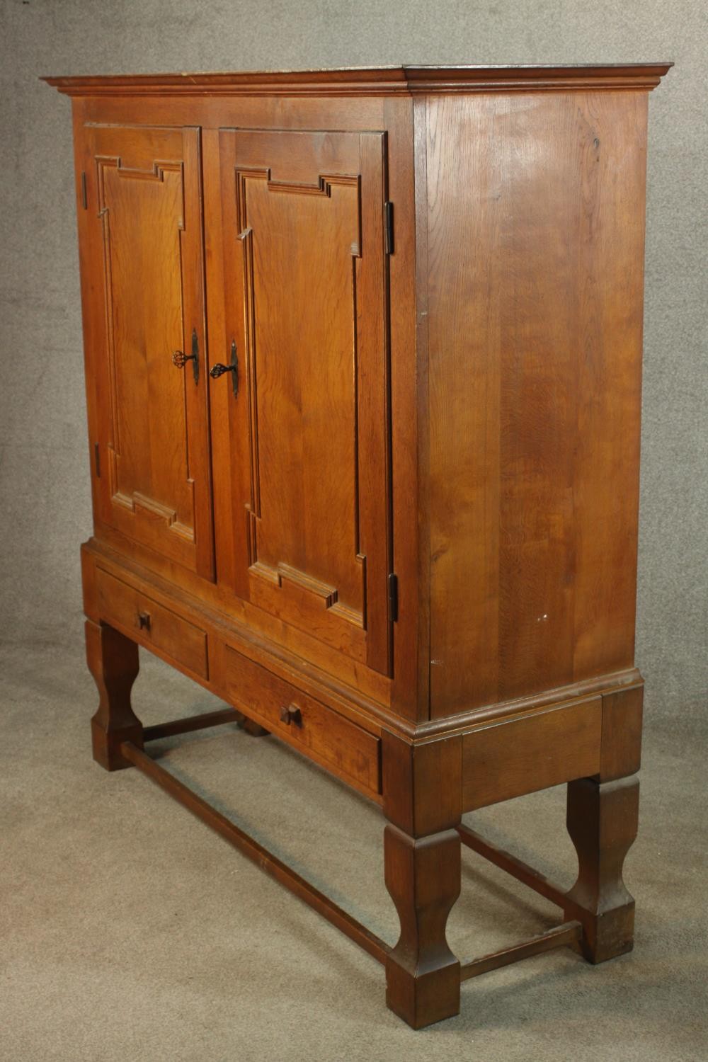 A late 19th century oak two door cupboard with two drawers below, raised on heavily carved - Image 5 of 10