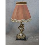 A 20th century cast brass cherub table lamp standing on square marble base, raised on four brass
