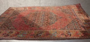 A large 20th century red ground Persian carpet, with allover floral decoration within floral border.