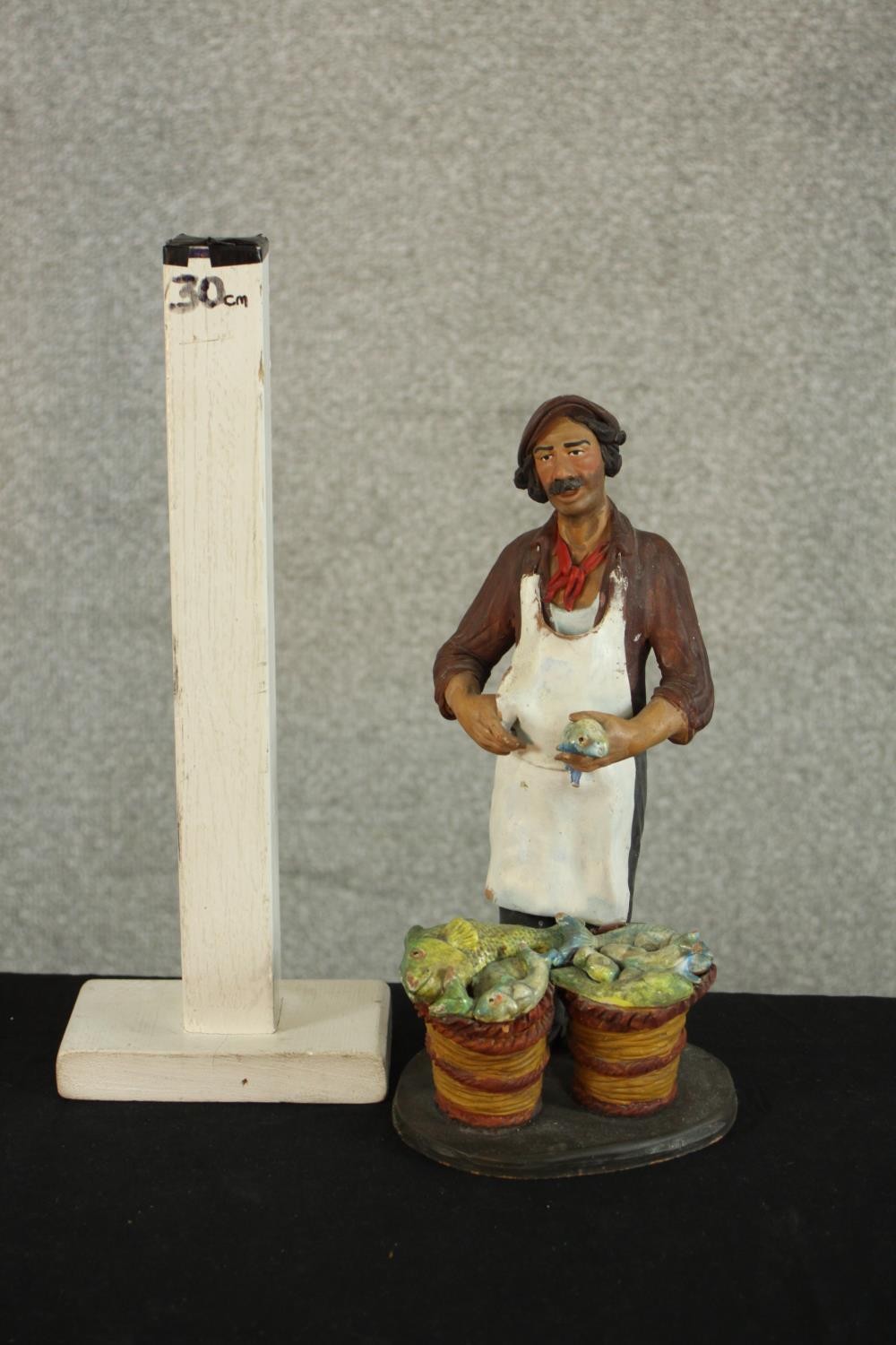 A 20th century Russian painted pottery figure of a a fishmonger, impressed marks. H.25 W.13 D.11cm. - Image 2 of 6
