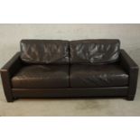 A contemporary black leather two seater settee, raised on shaped feet. H.80 W.195 D.90cm.