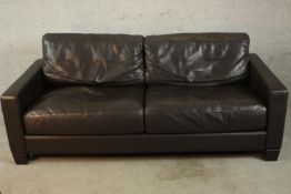 A contemporary black leather two seater settee, raised on shaped feet. H.80 W.195 D.90cm.