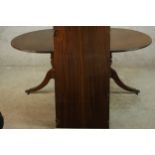 A 20th century Regency style mahogany twin pedestal dining table, raised on turned columns on tripod
