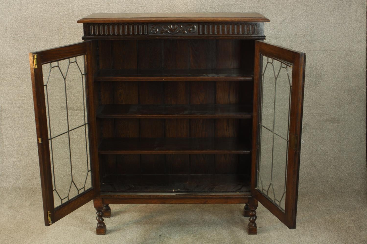 An early 20th century carved oak twin door leaded glass display cabinet, raised on turned supports - Image 3 of 9