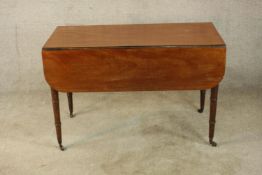 A 19th century mahogany Pembroke table, raised on square tapering supports terminating in casters.