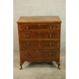 A 20th century walnut veneered chest of four graduating drawers, with brass swing handles, raised on