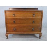 An early 20th century mahogany veneered chest of three long drawers, with swing handles, raised on
